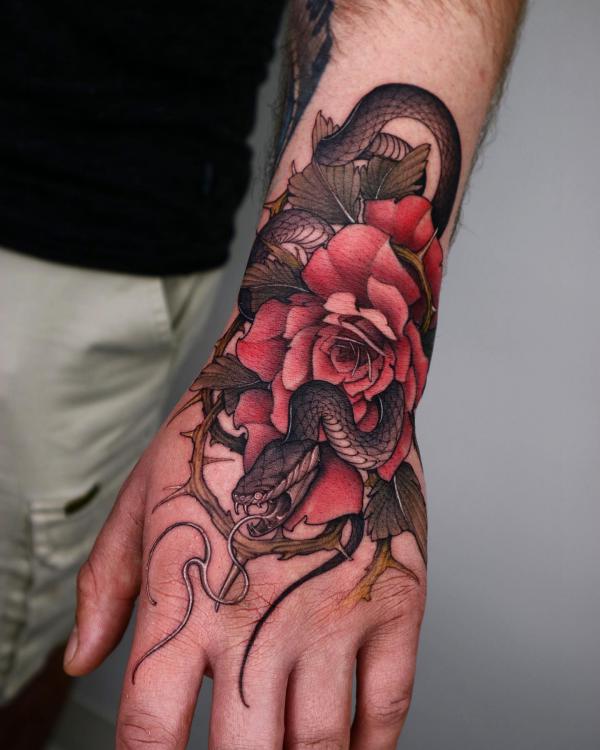 Snake and rose with thorns tattoo on hand