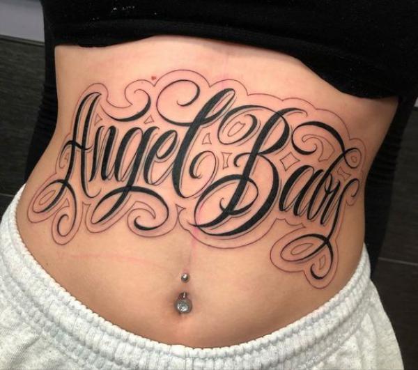Stylish lettering stomach tattoo