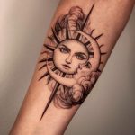Sun and moon face forearm tattoo