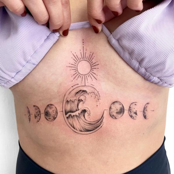 Sun and moon phases with wave stomach tattoo