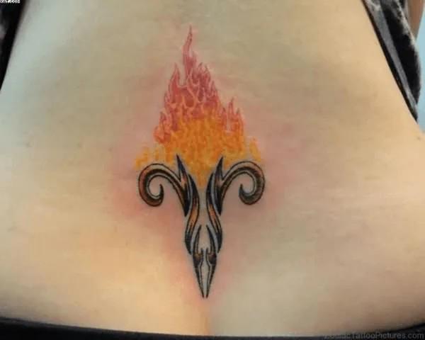 Tribal Aries with fire low back tattoo