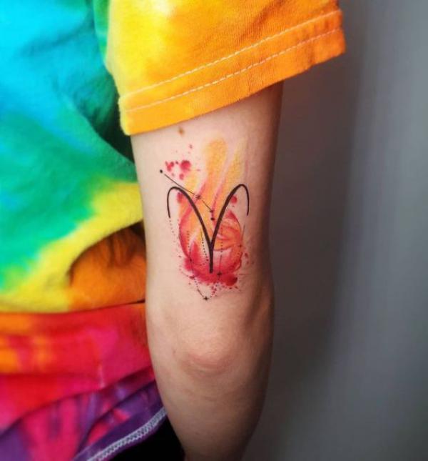 Watercolor Aries glyph and constellation tattoo above elbow