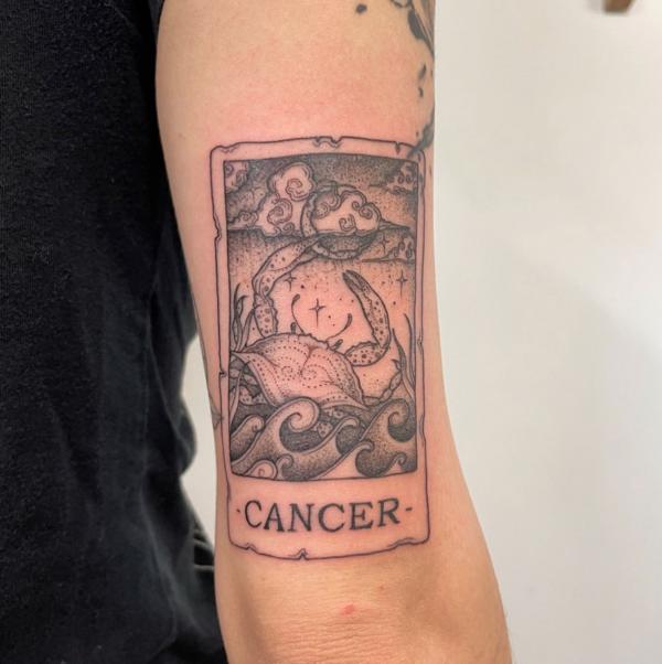 Zodiac cancer card tattoo above elbow