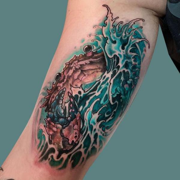 Zodiac cancer crab in wave bicep tattoo