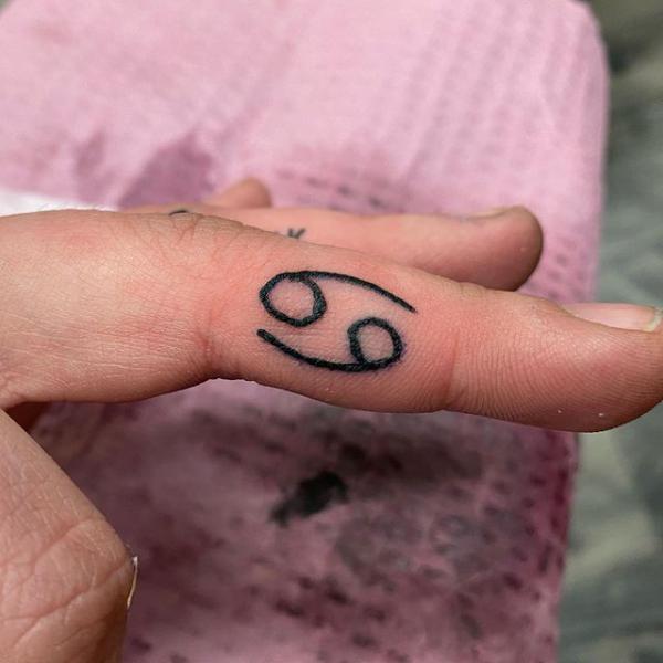 Zodiac cancer glyph finger tattoo