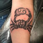 Zodiac cancer holding glyph tattoo on inner forearm