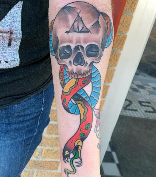 death eater with deathly hallows and colorful Nagini forearm tattoo