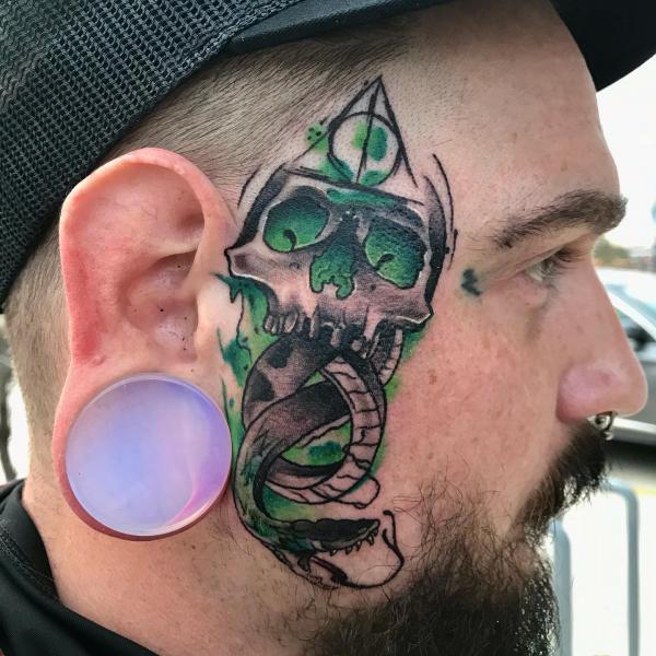 death eater with deathly hallows tattoo in front of ear