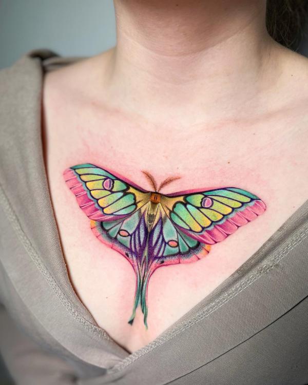 luna moth above boob tattoo