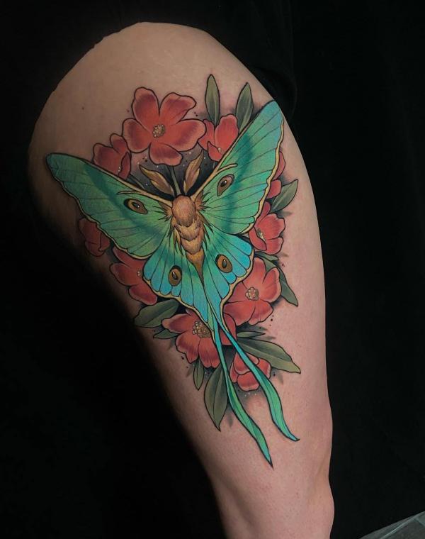 luna moth and flower upper arm tattoo