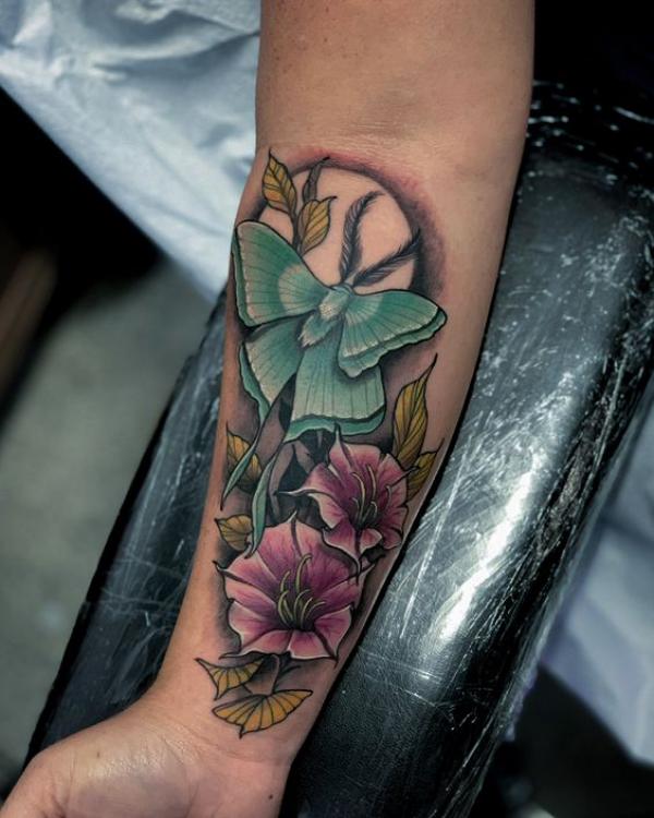 luna moth and flower with moon forearm tattoo