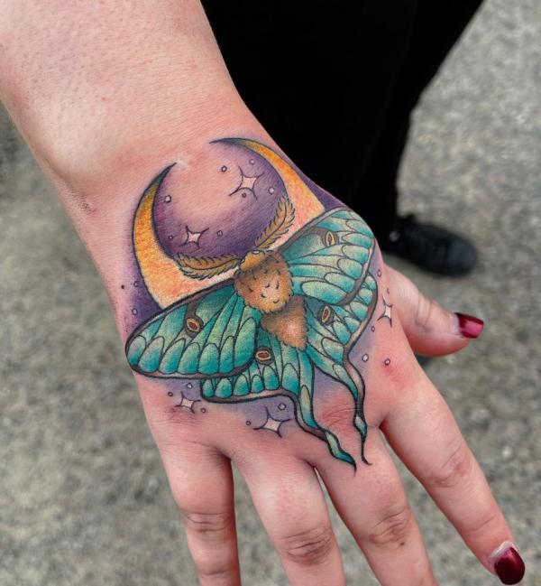 luna moth with crescent moon and stars tattoo on hand
