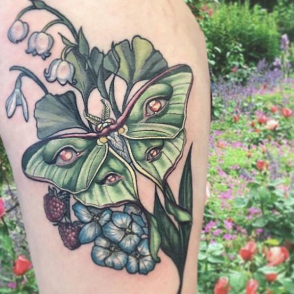 luna moth with eyes and berry flowers and lily of the valley tattoo