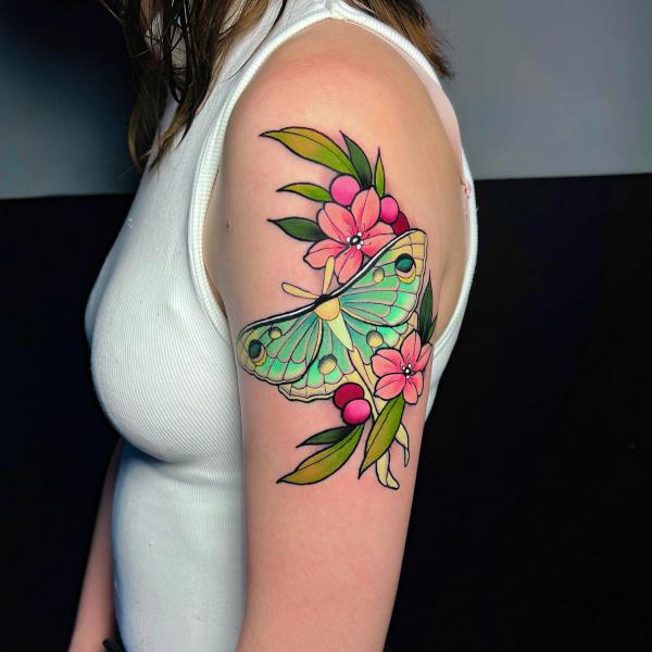 luna moth with flower upper arm tattoo