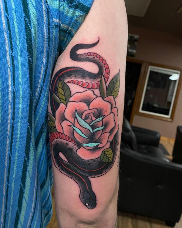 snake and rose back of arm tattoo traditional