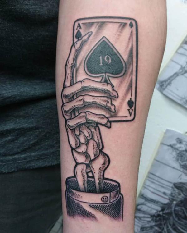 Ace of spades and skeleton hand tattoo