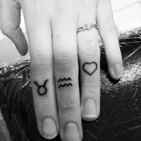 Aquarius and Taurus sign finger tattoo