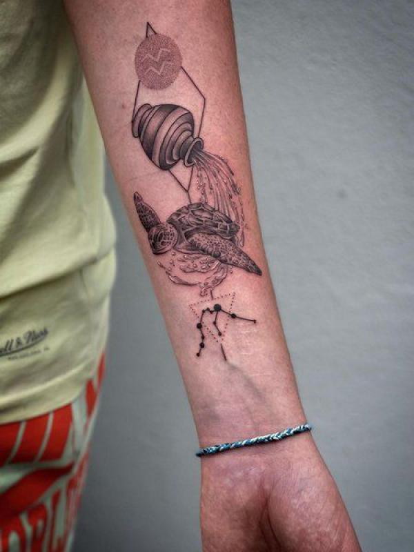 Aquarius water bearer and turtle tattoo on inner forearm