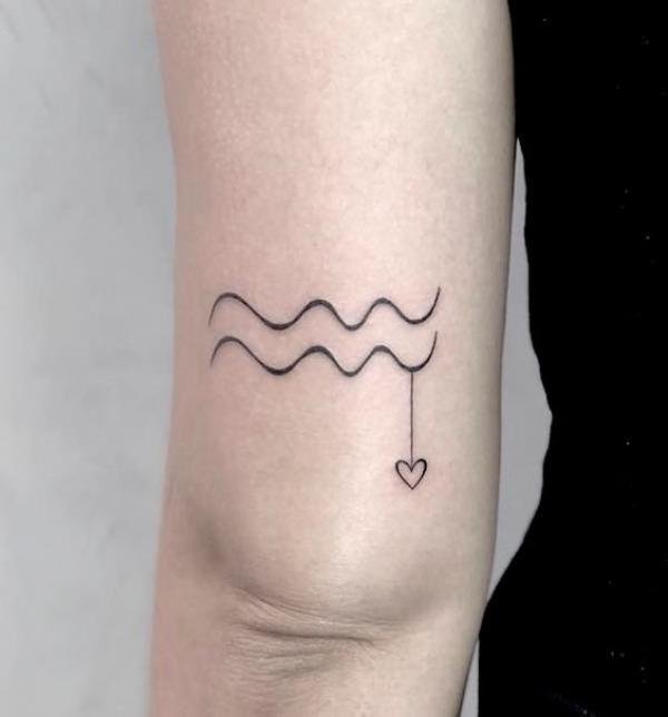 Aquarius with heart tattoo above the knee