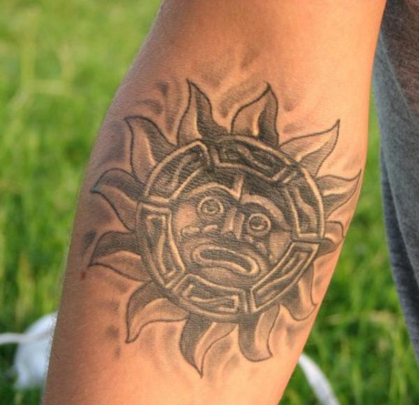 Aztec sun tattoo on inner forearm