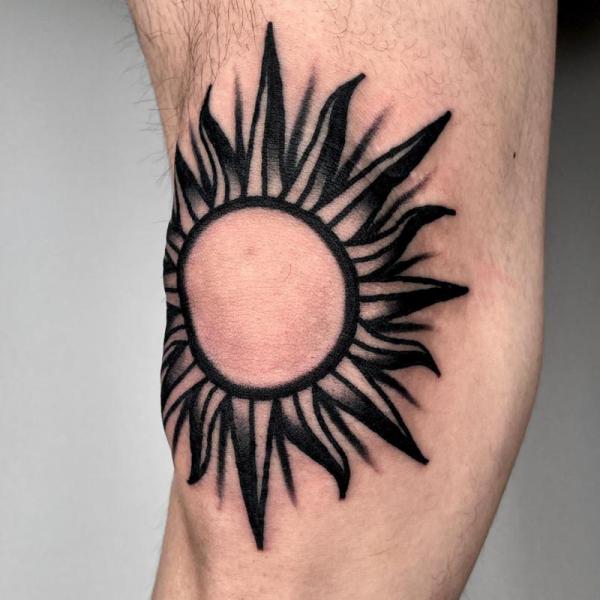 Black and white sun knee tattoo