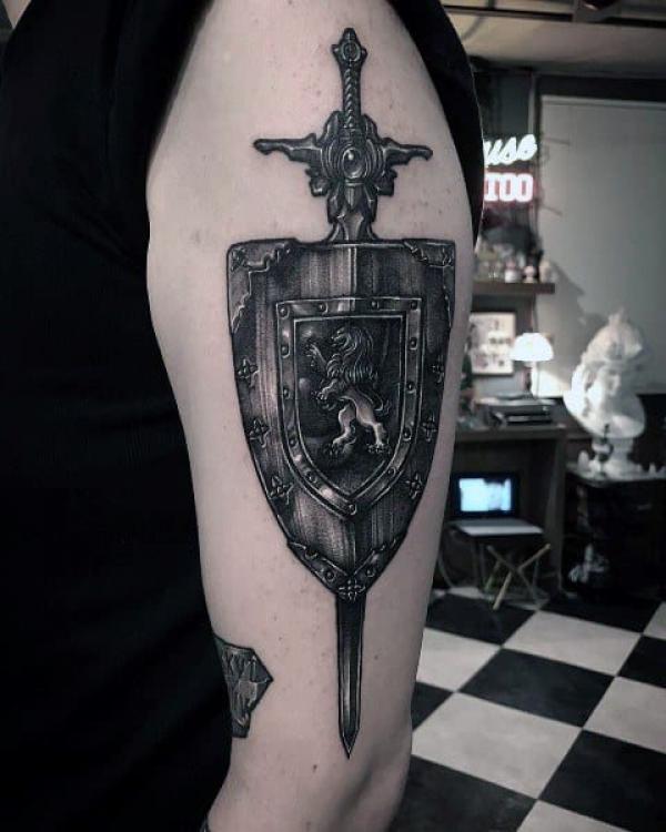 Blackwork shield with sword and lion tattoo