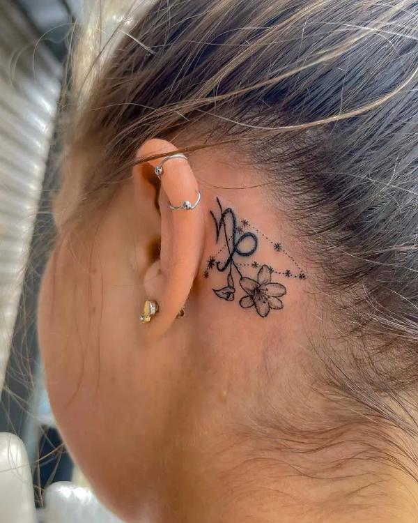 Capricorn constellation and glyph with flower tattoo behind the ear