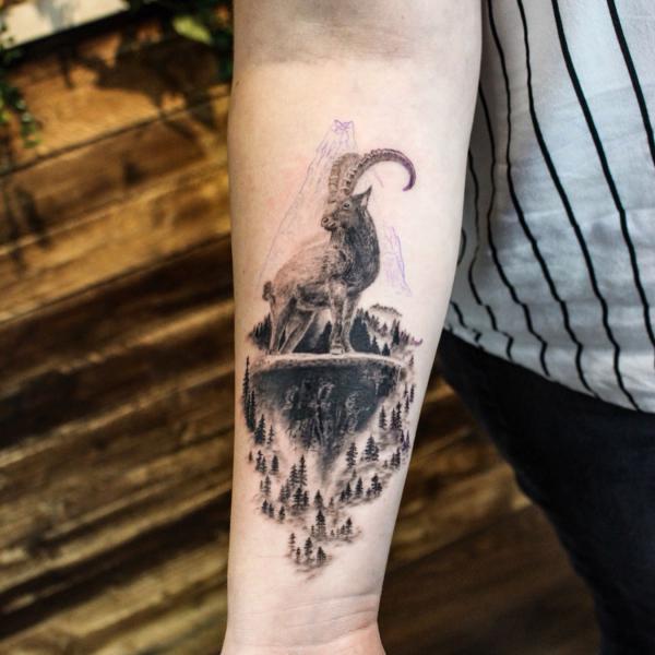 Capricorn goat and earth forest tattoo forearm