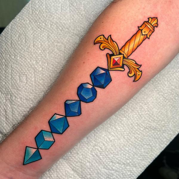 Dice sword tattoo on forearm