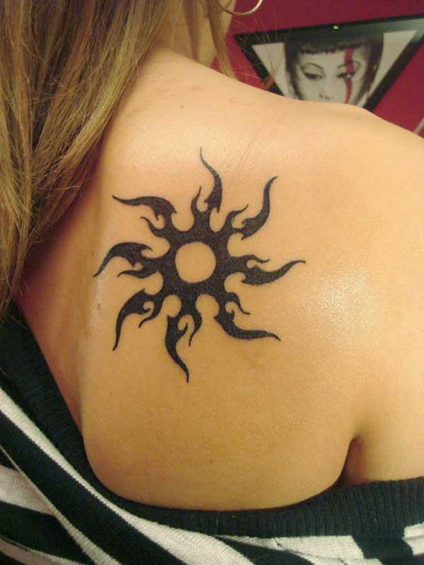 Feminine tribal sun tattoo on shoulder blade
