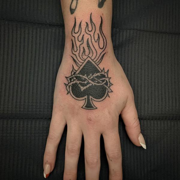Fire and ace of spade wrapped with barbed wire tattoo hand