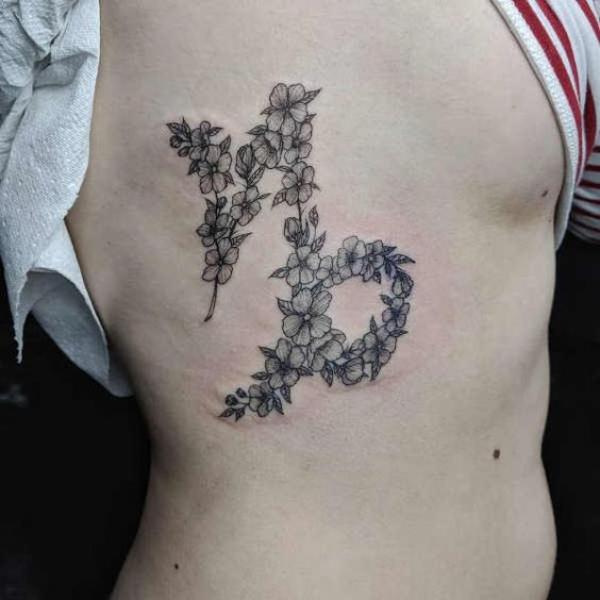 Flower Capricorn glyph side tattoo