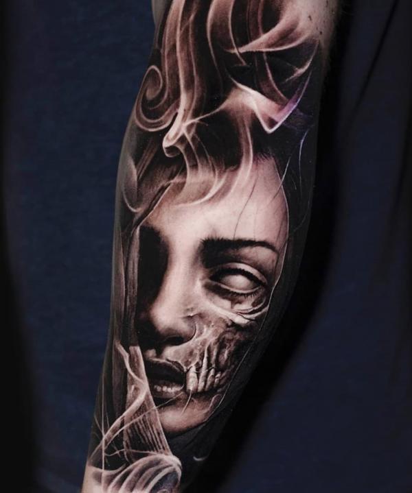 Gothic face with smoke tattoo forearm