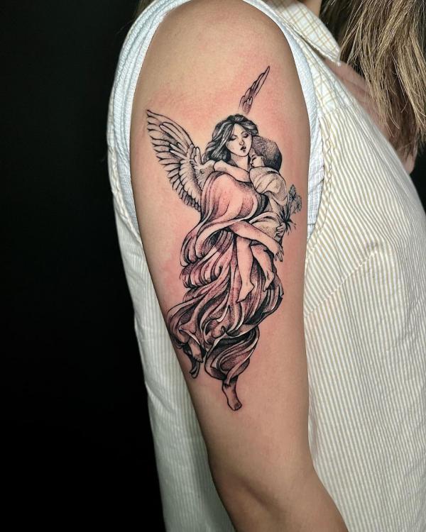 Guardian angel holding a baby tattoo on upper arm