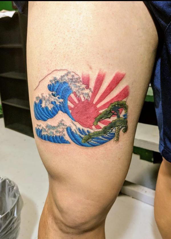 Japanese rising sun and wave tattoo thigh