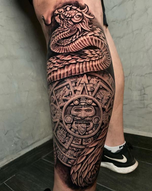 Quetzalcoatl and sun God tattoo leg