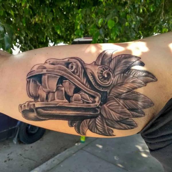 Quetzalcoatl head tattoo bicep