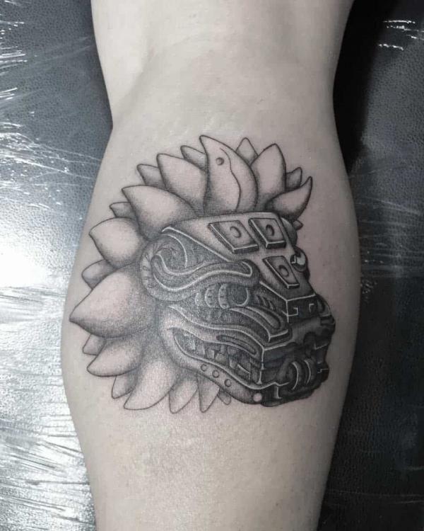 Quetzalcoatl head tattoo on calf
