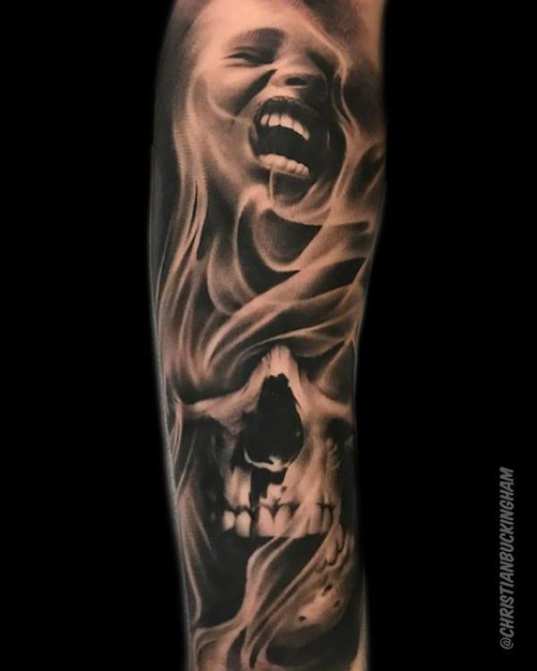 Realistic face and skull in smoke tattoo