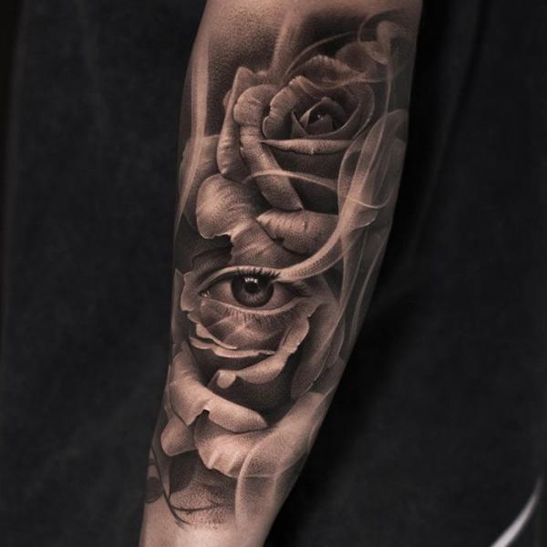 Realistic rose with eye in smoke tattoo forearm