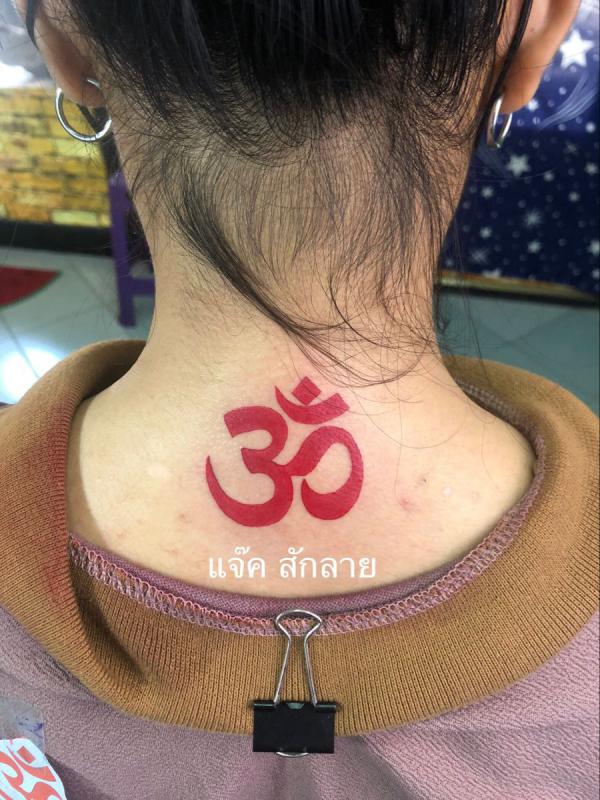Red OM tattoo on back of neck