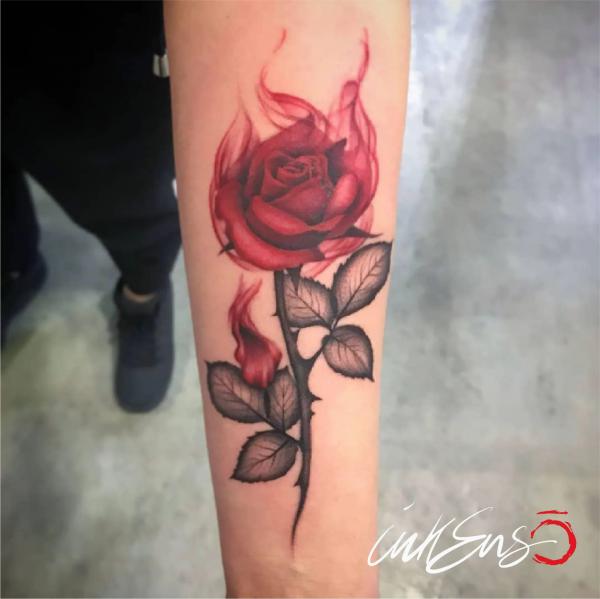 Red rose in smoke tattoo forearm
