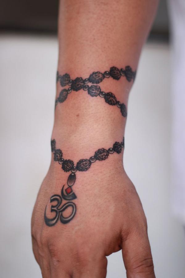 Rosary with OM tattoo on hand