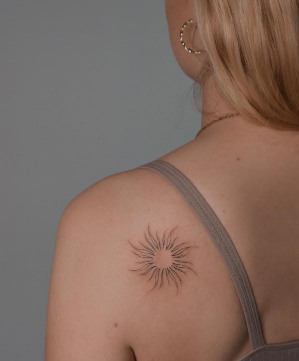 Simple sun tattoo shoulder blade