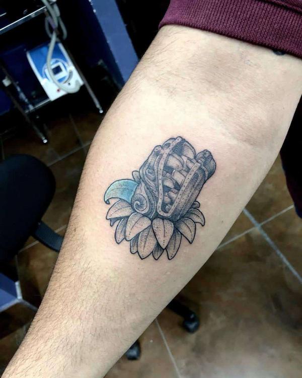 Small Quetzalcoatl head tattoo forearm