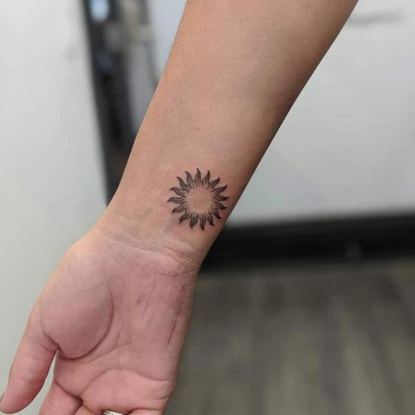 Small sun wrist tattoo