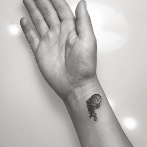 Small water bearer tattoo wrist