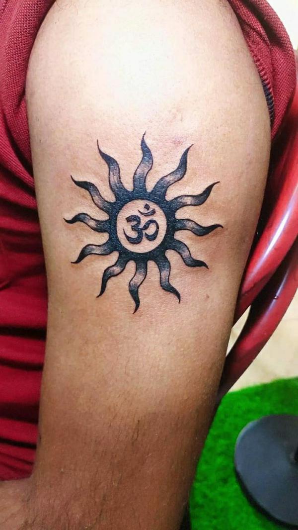 Sun with OM symbol upper arm tattoo