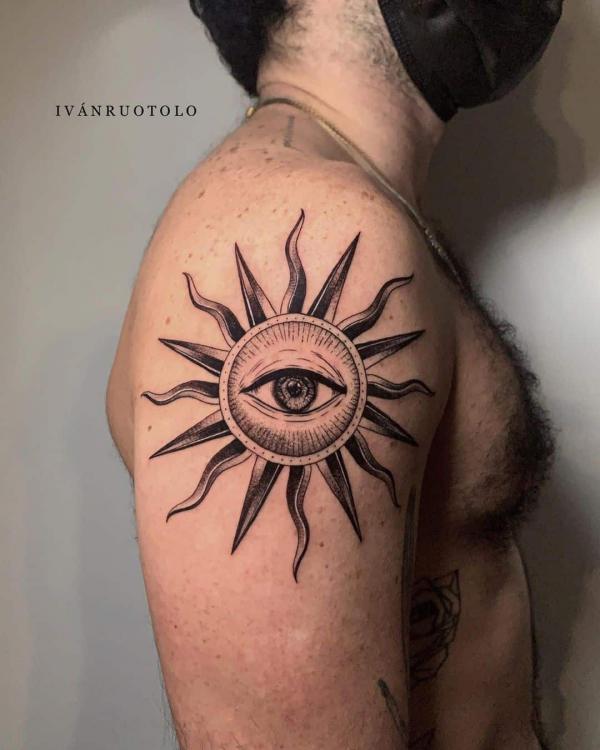 Sun with eye tattoo on upper arm