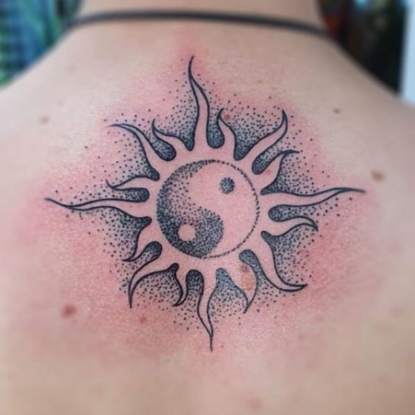 Sun yin yang tattoo on upper back